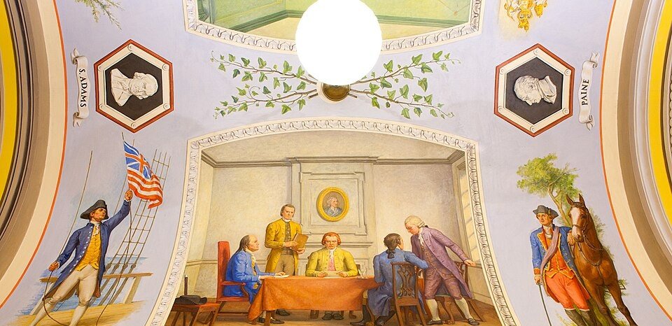 Painted mural of eighteenth century delegates seated around a table in a panelled room.
