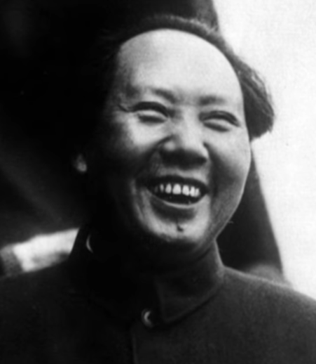 Black and white photograph of a laughing man in a high collared tunic and cap.