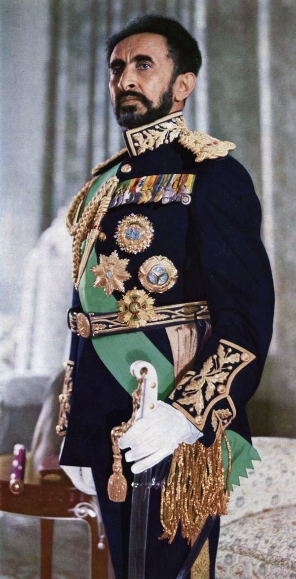 Formal portrait of an elderly man in ornate military full dress uniform with heavy braid and medals.